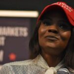 Legal Threats Escalate Owens–Crowder War woman in a red cap holding a microphone