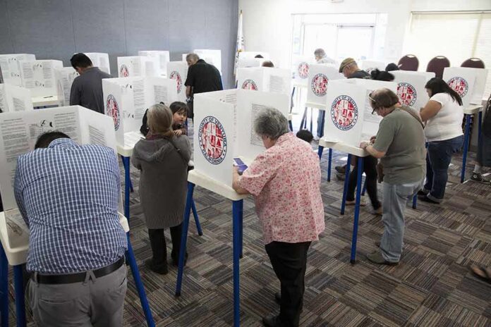 Voters fill out ballots at polling booths in a busy voting room