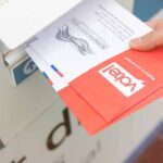 Mail-Ballot Overhaul Runs Into a Judicial Roadblock Hand dropping mail-in ballots into a drop box