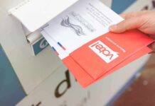 Mail-Ballot Overhaul Runs Into a Judicial Roadblock Hand dropping mail-in ballots into a drop box