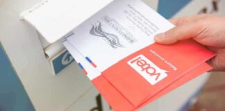 Hand dropping mail-in ballots into a drop box