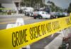 crime scene tape stretches across a blocked city street