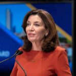 Hochul’s Mask Crackdown COLLAPSES in Court woman speaking at a podium with microphones