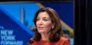woman speaking at a podium with microphones