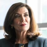 Hochul’s Whiplash: ICE Help, Then Handcuffs woman in business attire looking to the side