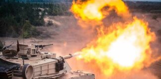 tank firing main gun with bright muzzle flash