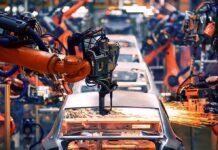 Industrial robots welding a car body on an assembly line