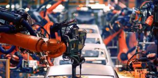 Industrial robots welding a car body on an assembly line