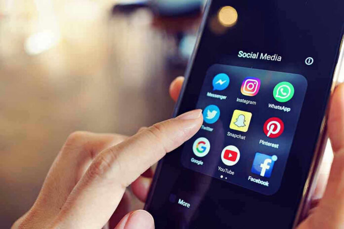 1064490605 Finger tapping smartphone social media app icons.