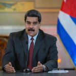 One Title Could Upend Maduro’s Prosecution Man speaking at podium with Cuban flag in background.