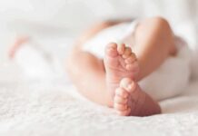Hormone Surge In A Baby? Doctors Move baby feet on a soft white blanket