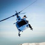 helicopter banking over snowy mountains