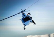 helicopter banking over snowy mountains
