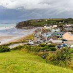 Coastal village by a wide sandy beach under cloudy skies