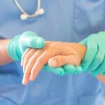 Euthanasia Shock: Consent Vanished? Healthcare worker in gloves holding a patient's hand