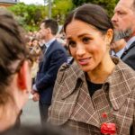 Netflix Hype Machine Spins — Where’s The Proof? woman in plaid coat speaking to a person in a crowd