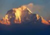 Snow-capped mountain peak glowing at sunrise