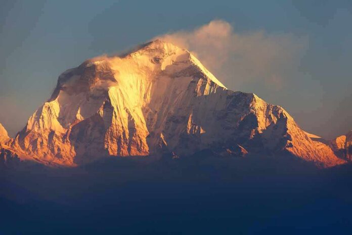 Snow-capped mountain peak glowing at sunrise