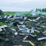 Aircraft crash debris scattered across a grassy field