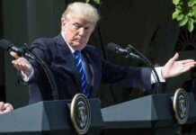 Donald Trump speaking at dual podiums with arms outstretched