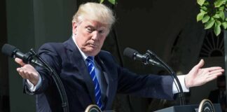 Donald Trump speaking at dual podiums with arms outstretched