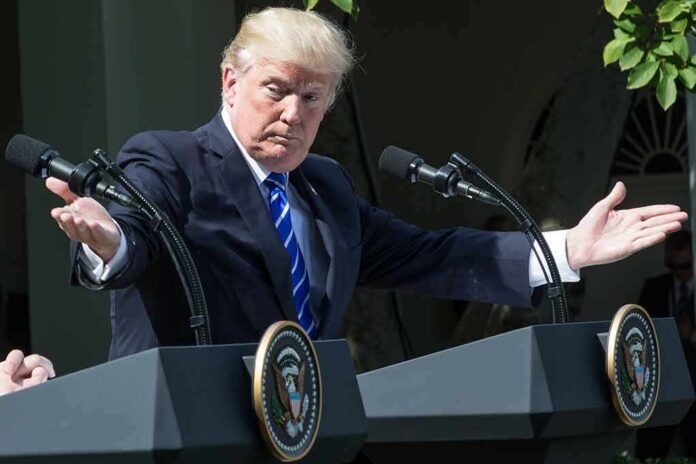 shutterstock_1456093781 Donald Trump speaking at dual podiums with arms outstretched