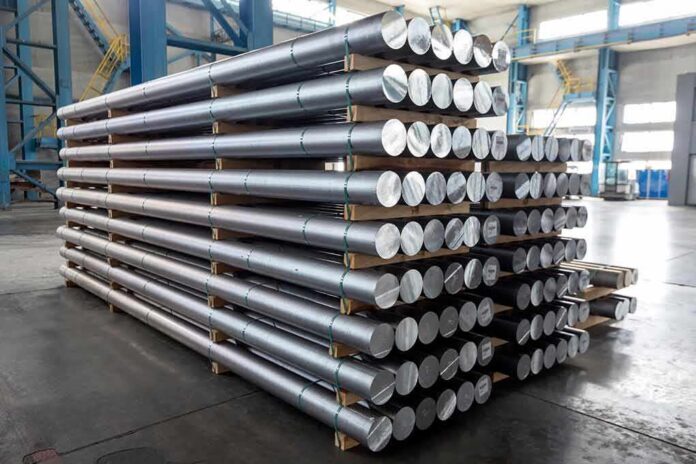 shutterstock_1472538056 Stacked metal rods on pallets in an industrial warehouse