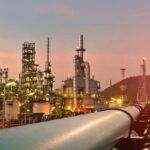 Oil refinery with pipelines at sunset