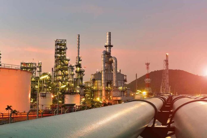 shutterstock_1569942199 Oil refinery with pipelines at sunset