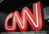 Large red CNN logo outside a modern building entrance