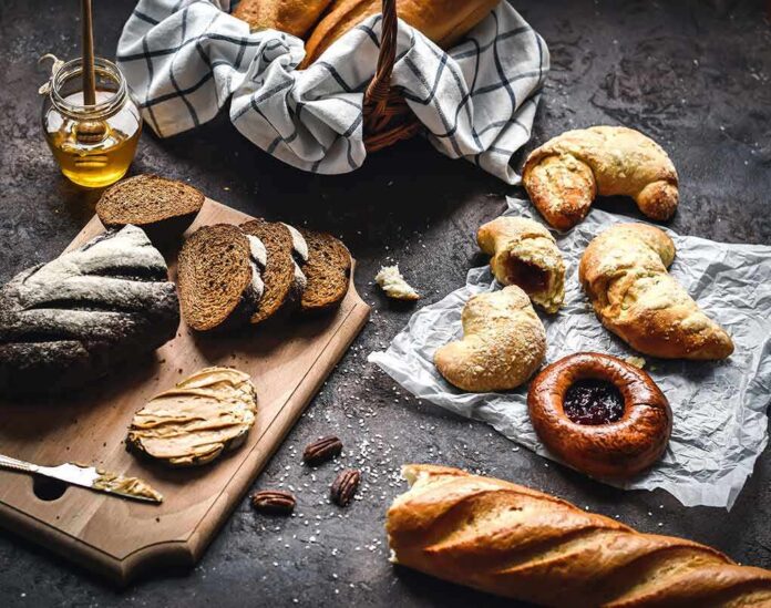 shutterstock_1665323011 Assorted breads and pastries on a dark rustic surface