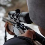 Sniper Watch Spotted – No One Told the Feds person aiming a rifle with a scope outdoors