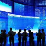 An Old Culture-War Warning Comes Roaring Back Silhouetted business professionals in front of digital stock market displays