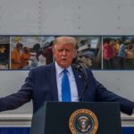 The Next Iran Offensive Hits The Wallet Donald Trump speaks at a podium with arms outstretched