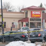 Police vehicles outside a grocery store with yellow tape