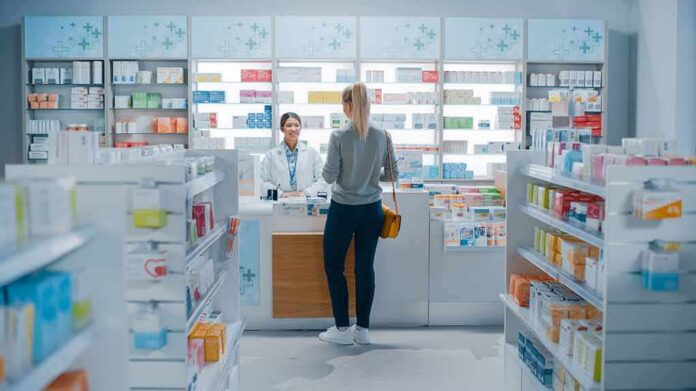 shutterstock_1952231947 Yvonne Li assisting a customer at a pharmacy counter