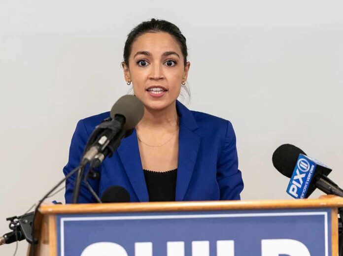 shutterstock_2004757316 Woman in blue blazer speaking at a press conference podium