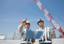 Donor Cash Or Tax Hit? Ballroom Mystery Two construction workers reviewing plans at a site with cranes