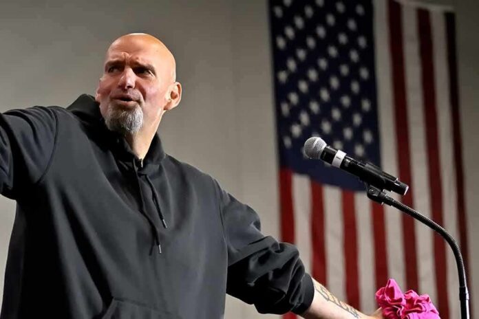shutterstock_2206788181 Bald man speaking at a microphone with a U.S. flag in the background