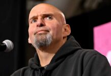 Fetterman’s Latest Slip Was Almost Too Perfect bald man with goatee speaking at a microphone