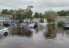 Torrents Paralyze Capital – Shelters Overflow Flooded residential street with partially submerged cars