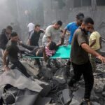 Rescuers Race: Trapped In Collapsed Mall Rescuers carry an injured person on a stretcher through rubble