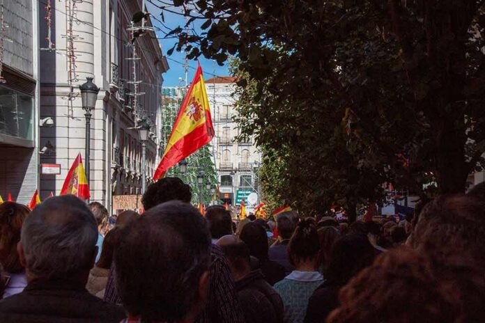shutterstock_2387482013 Crowd with Spanish flags in a city street