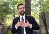 9/11 Stage Stunner Rocks City Hall man in a suit speaking outdoors with hands on chest
