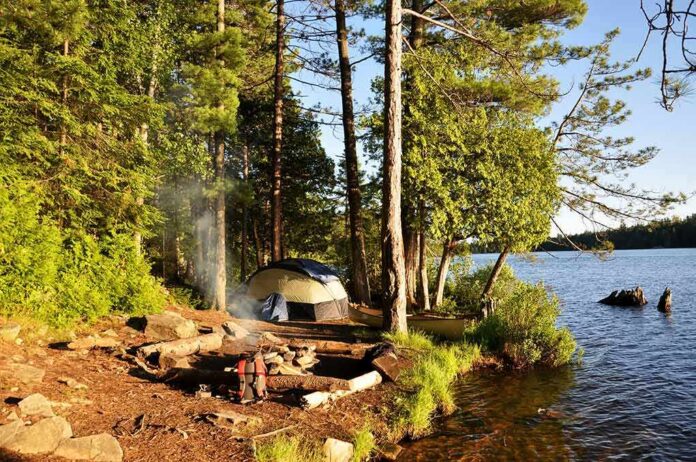 shutterstock_56940184 Tent and campfire by a forested lakeshore at sunset