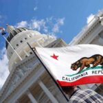 Shock Poll Upends California California state flag in front of a white domed capitol building