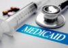 Stethoscope and syringe beside Medicaid label
