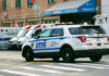 Police car and ambulances outside emergency room entrance.