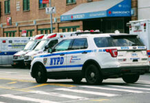 Motorbike Muggers: Detective Bleeds In Street Police car and ambulances outside emergency room entrance.