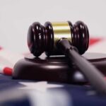 FBI Probes ICE Shooting – Case Stays Here Judge’s gavel on a base over an American flag